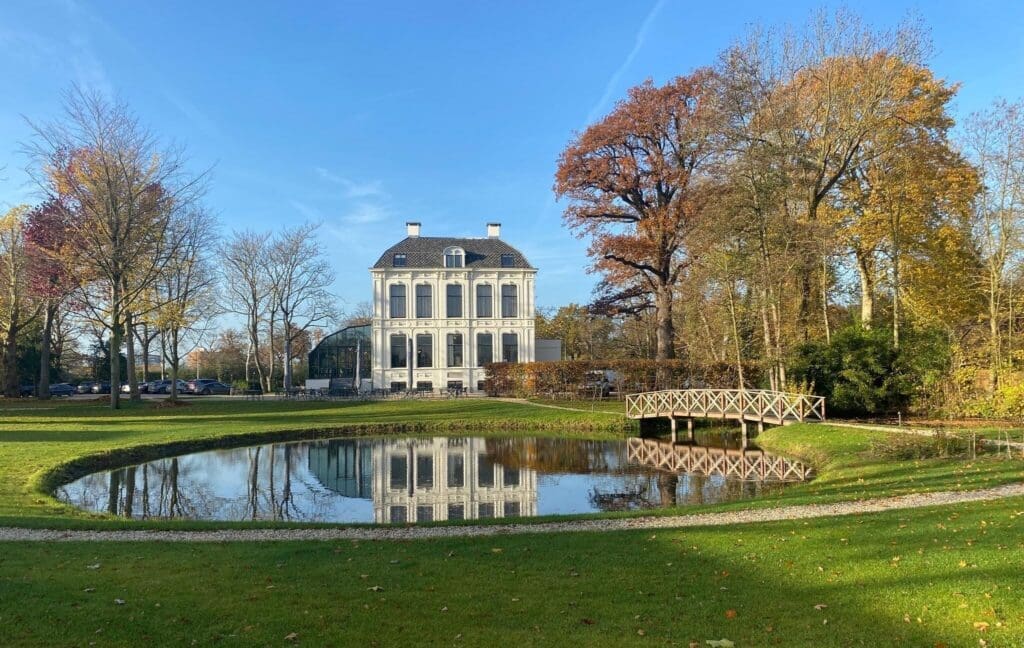 mooi groen gazon met grindpadjes en een meertje met brug