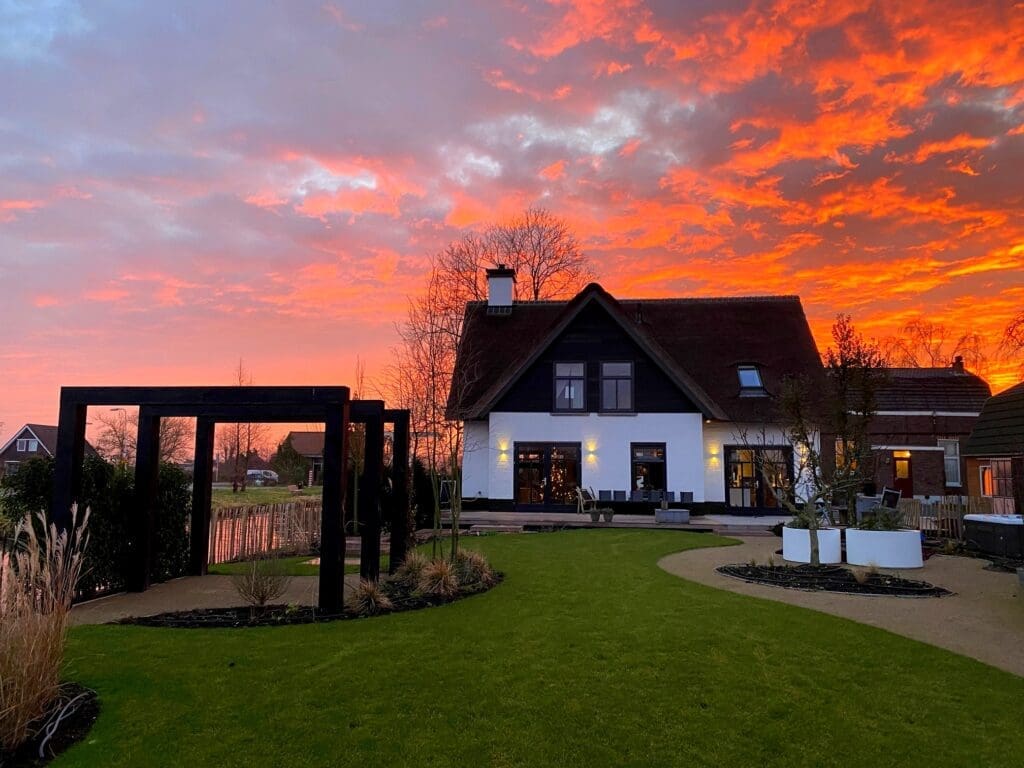 Landelijke villatuin met prachtig ochtendrood in de lucht.