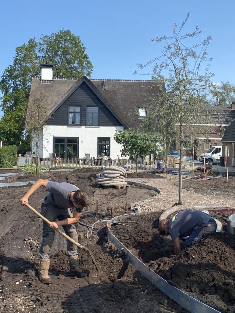 Hoveniers aan het werk met kantopsluitingen in aanleg van de landelijke villatuin.