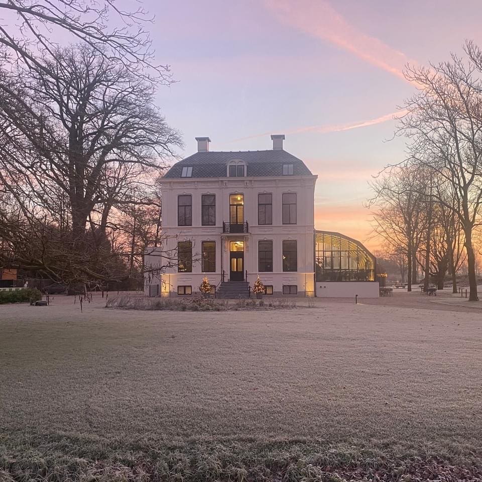 gazon met rijp met het sfeervolle hotel op de achtergrond