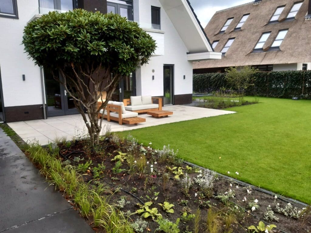 mooie net aangeplante gevulde border met beregeningsslang