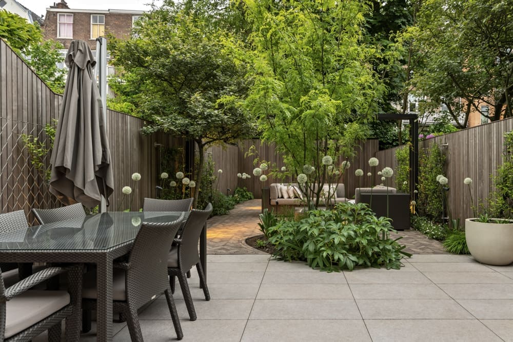 07 de Allium mooi in bloei het keramische terras met eettafel en de volle borders met de bollen van de allium