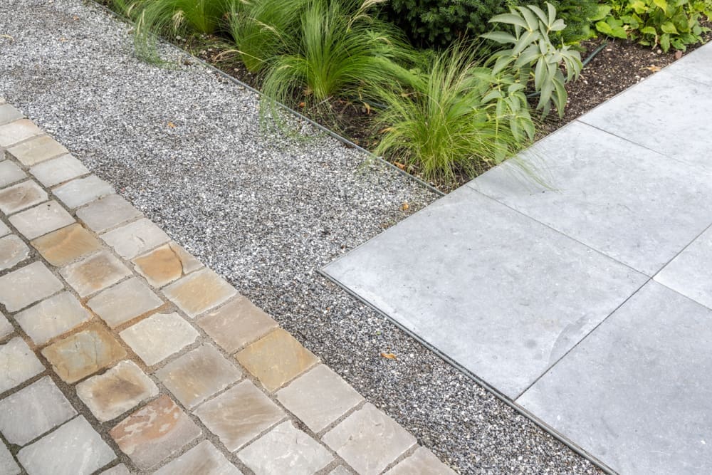 overgang van tegelpad op grindpad naar het terras