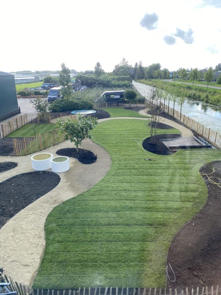 Vogelvlucht foto van landelijke tuin met organische vorm met net gelegde grasrollen.
