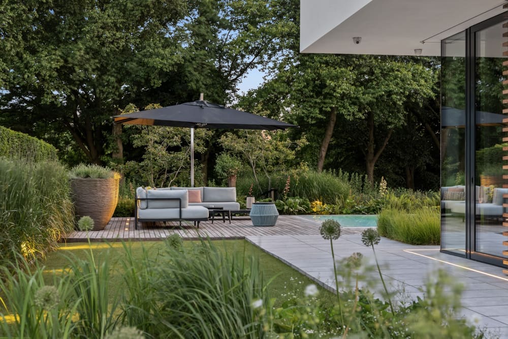 zijtuin met stukje kunstgras en tegelpad langs het huis