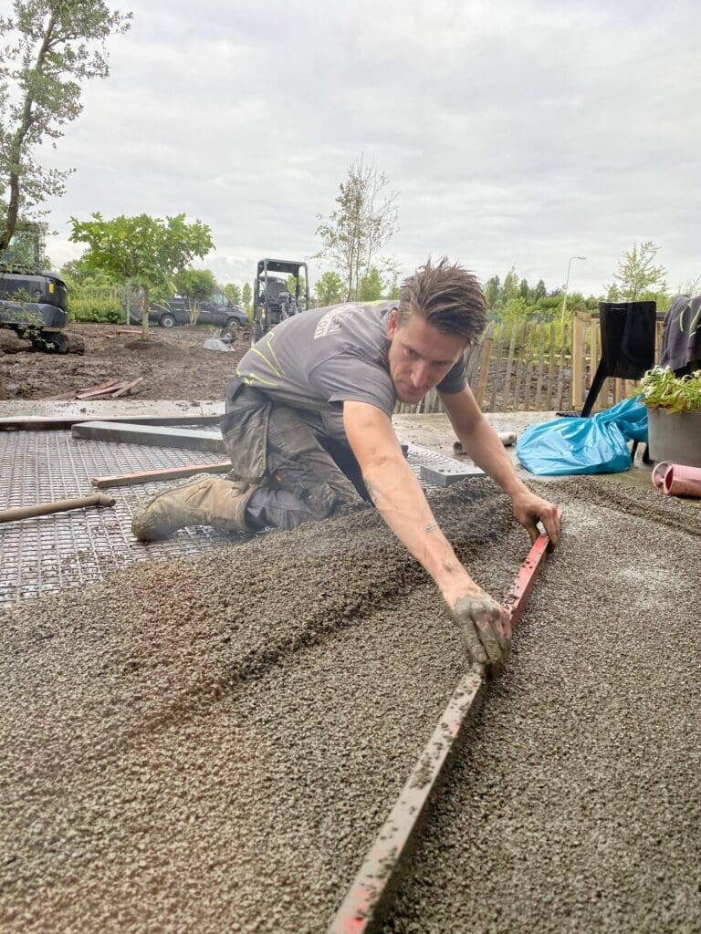 Werknemer in bedrijfskleding is mortel aan het vlakken.