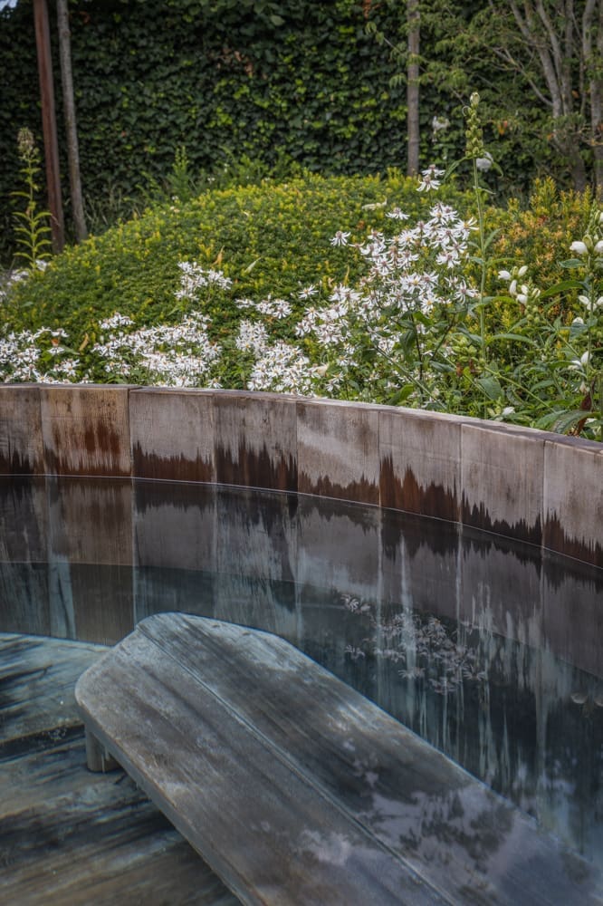 houten hottub naast de kleurijke border