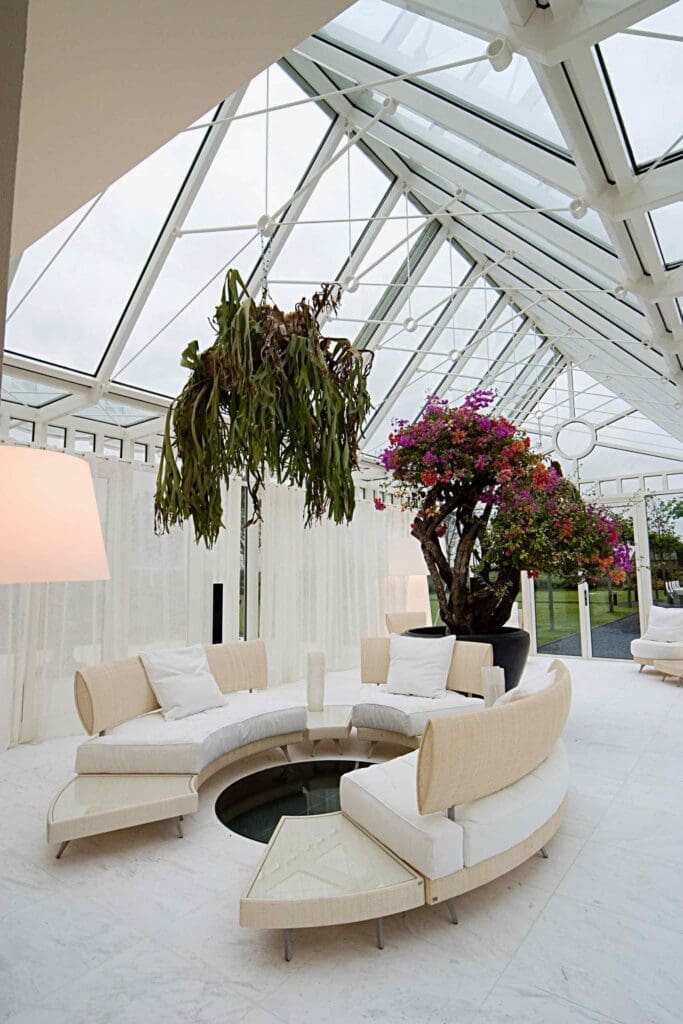 grote glazen serre ,et loungebank en grote hangplant