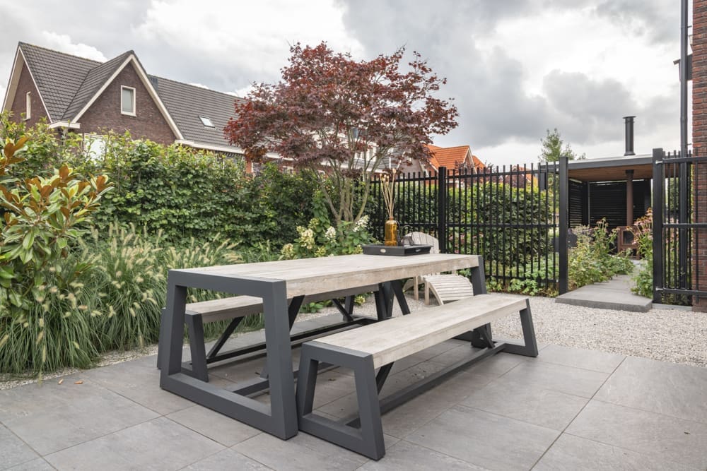 terras met moderne picknicktafel naast de gevulde border met grassen