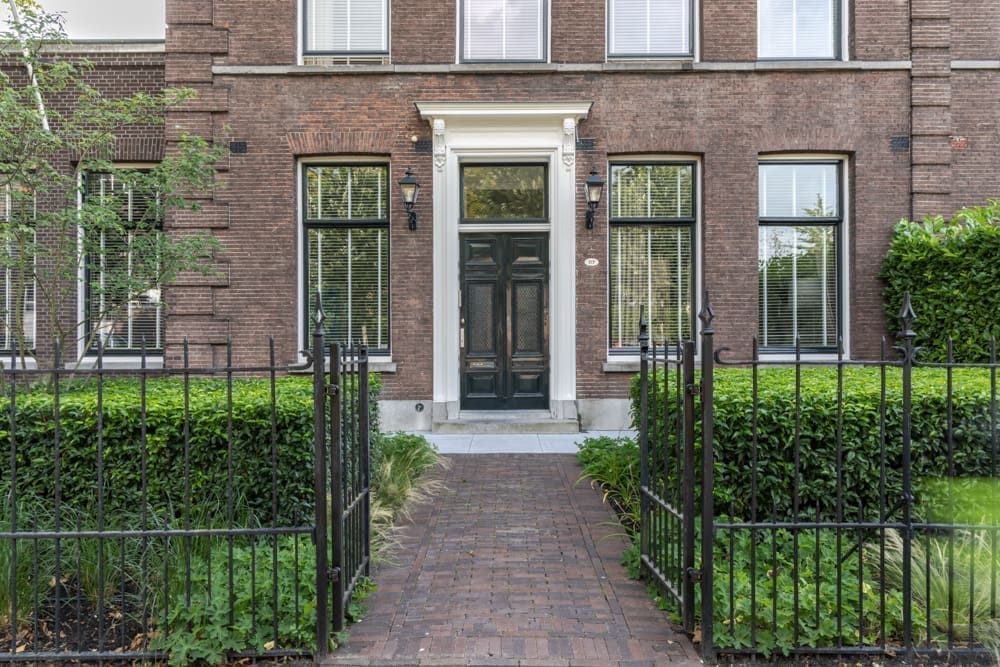 klinkerpad tussen de groene hagen door naar de voordeur