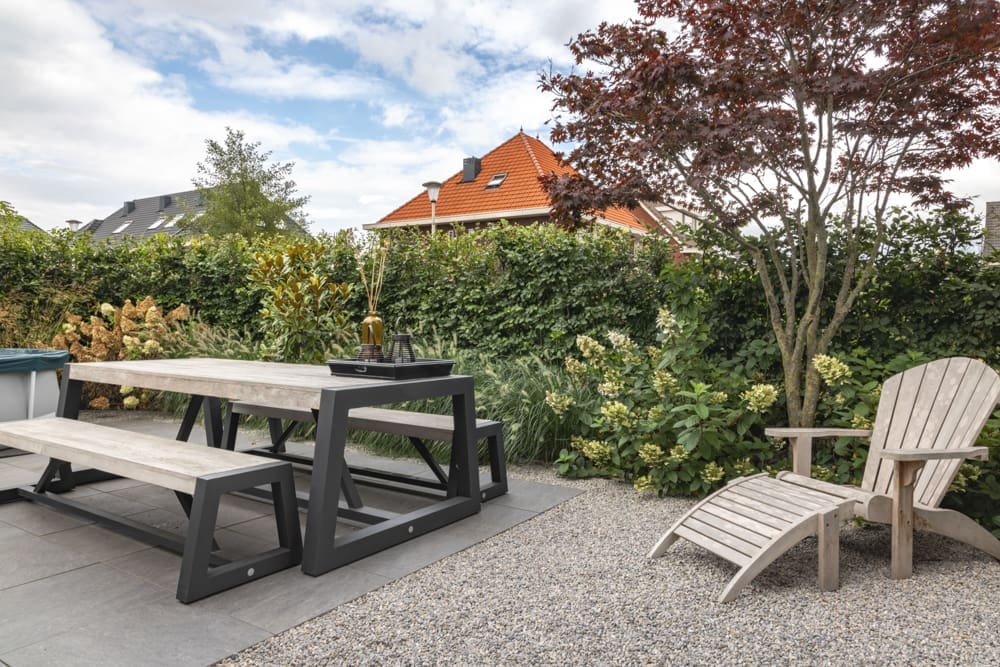 terras met picknicktafel en een ligbed op het grind