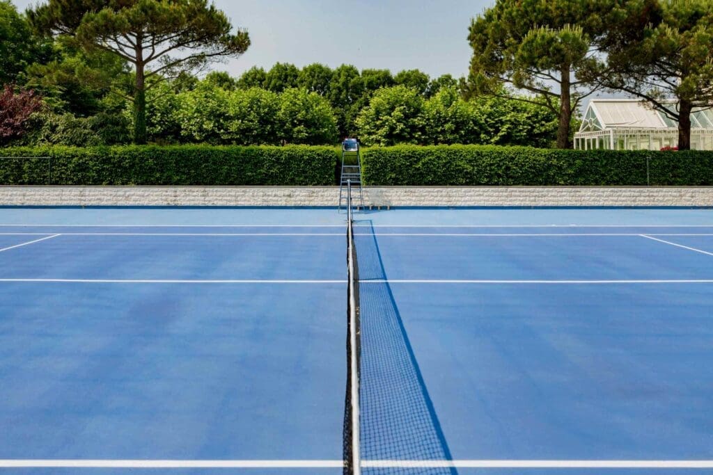 een echte wedstrijdtennisbaan omringd door mooie groene bebossing