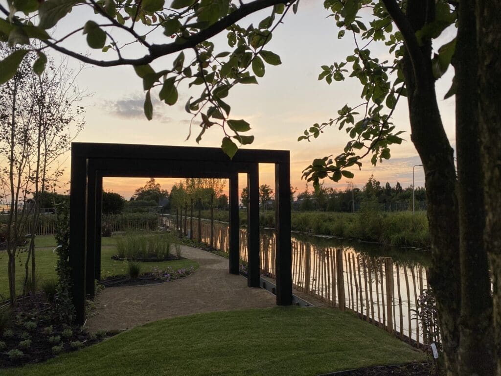 Robuuste zwarte pergola in landelijke tuin.