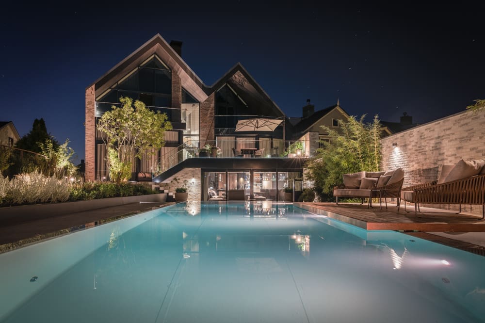infinitypool in het avondlicht met zwevend terras er boven