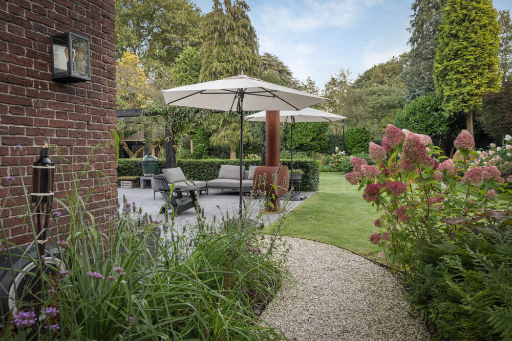 kijkje vanaf de zijtuin de landelijke tuin in met terras