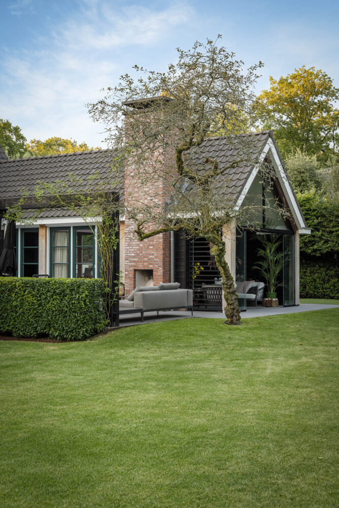 mooi stukje landelijke tuin met fruitboom voor het terras