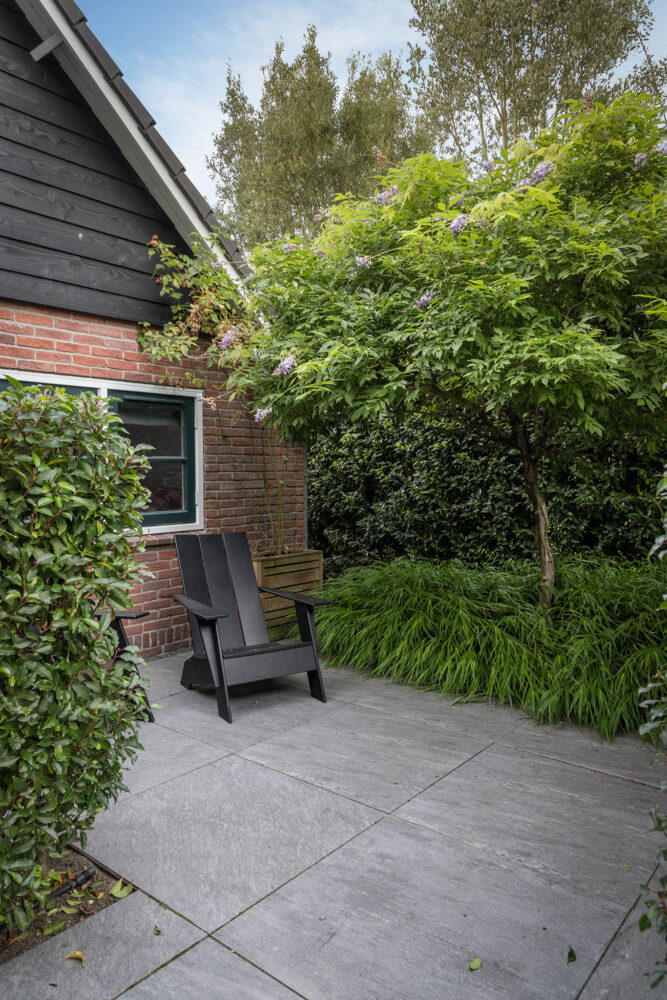 zithoekje omringt door groene beplanting