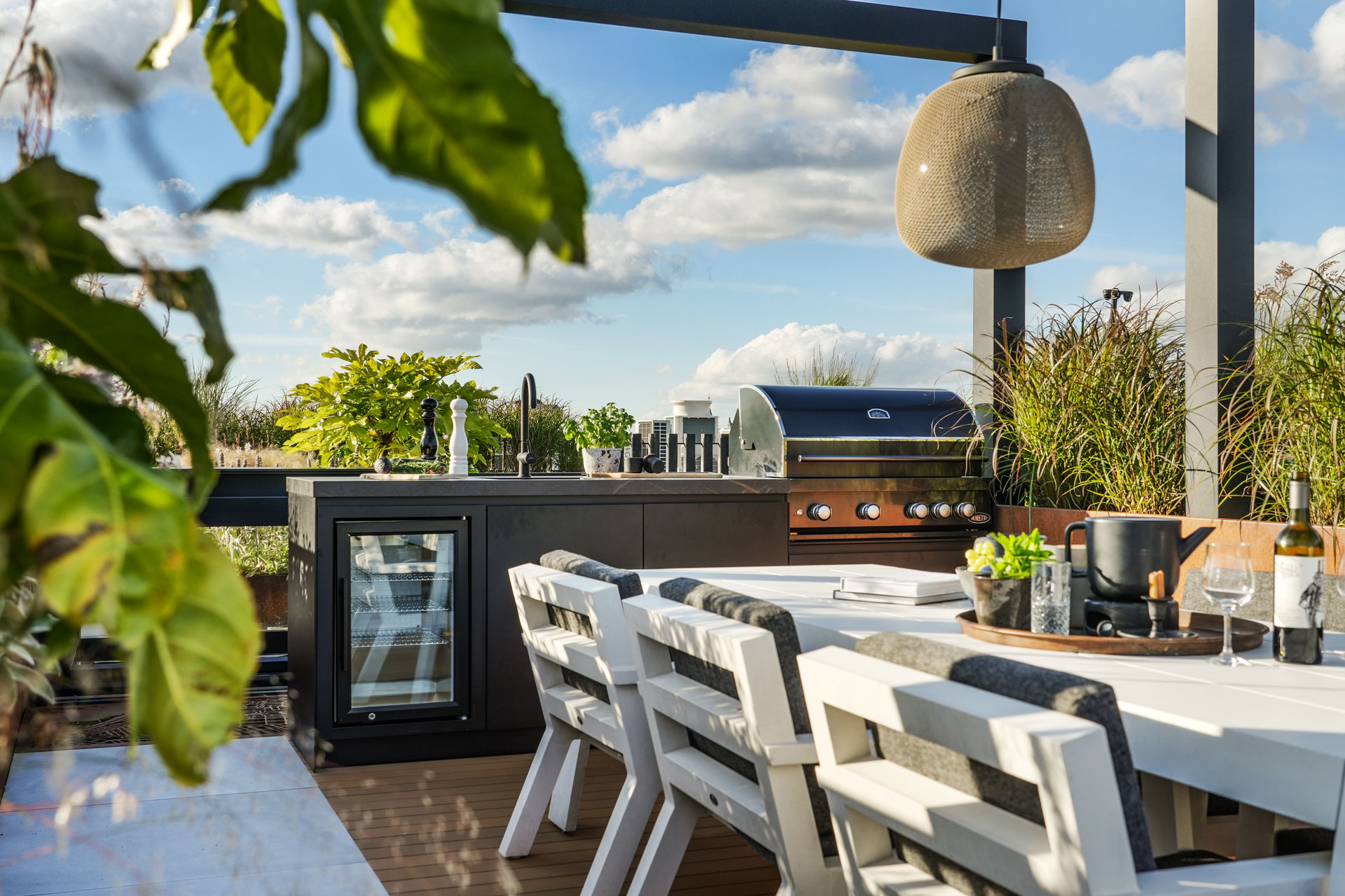 Buitenkeuken met bbq onder de pergola.