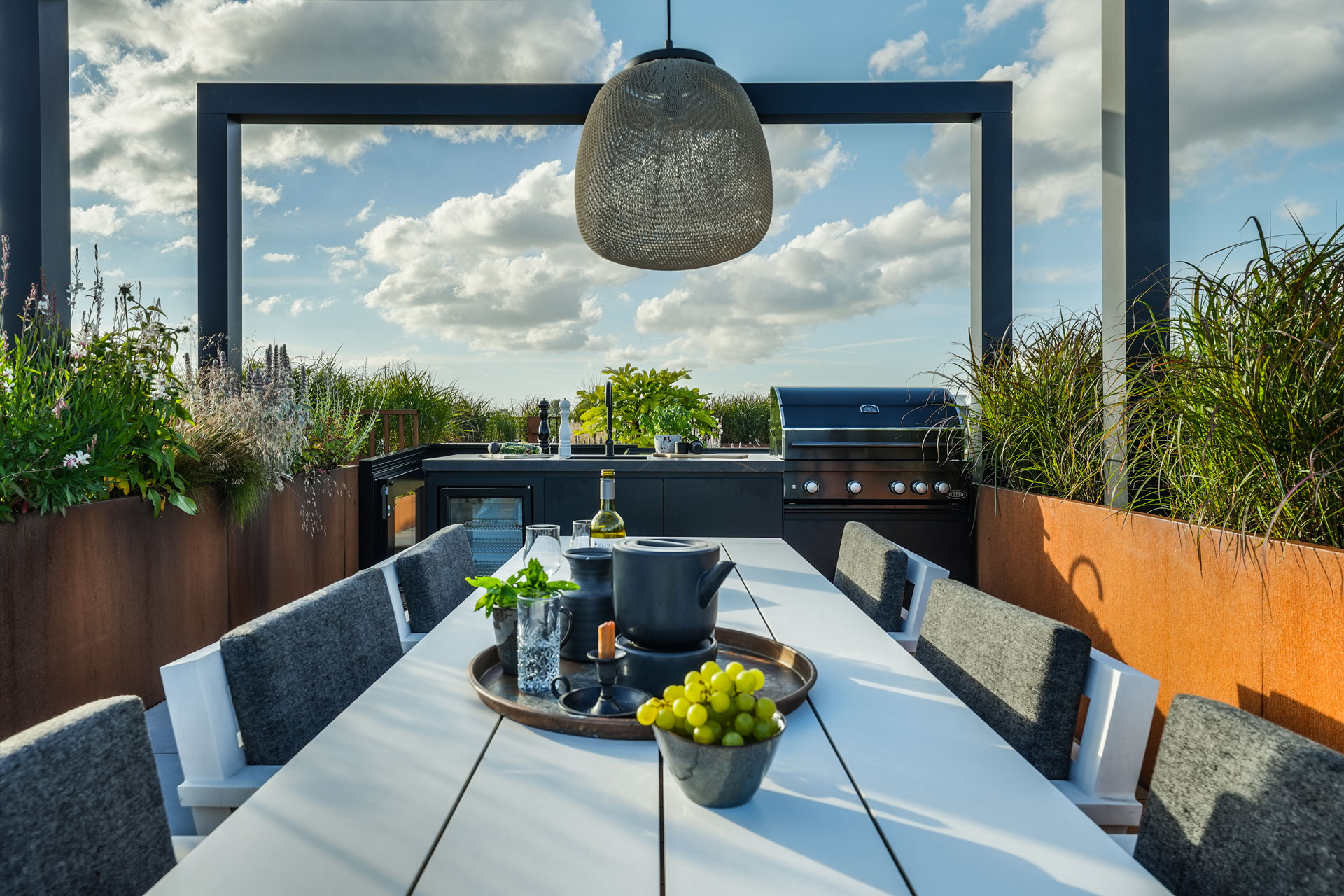 Eettafel onder de pergola met hanglampen.