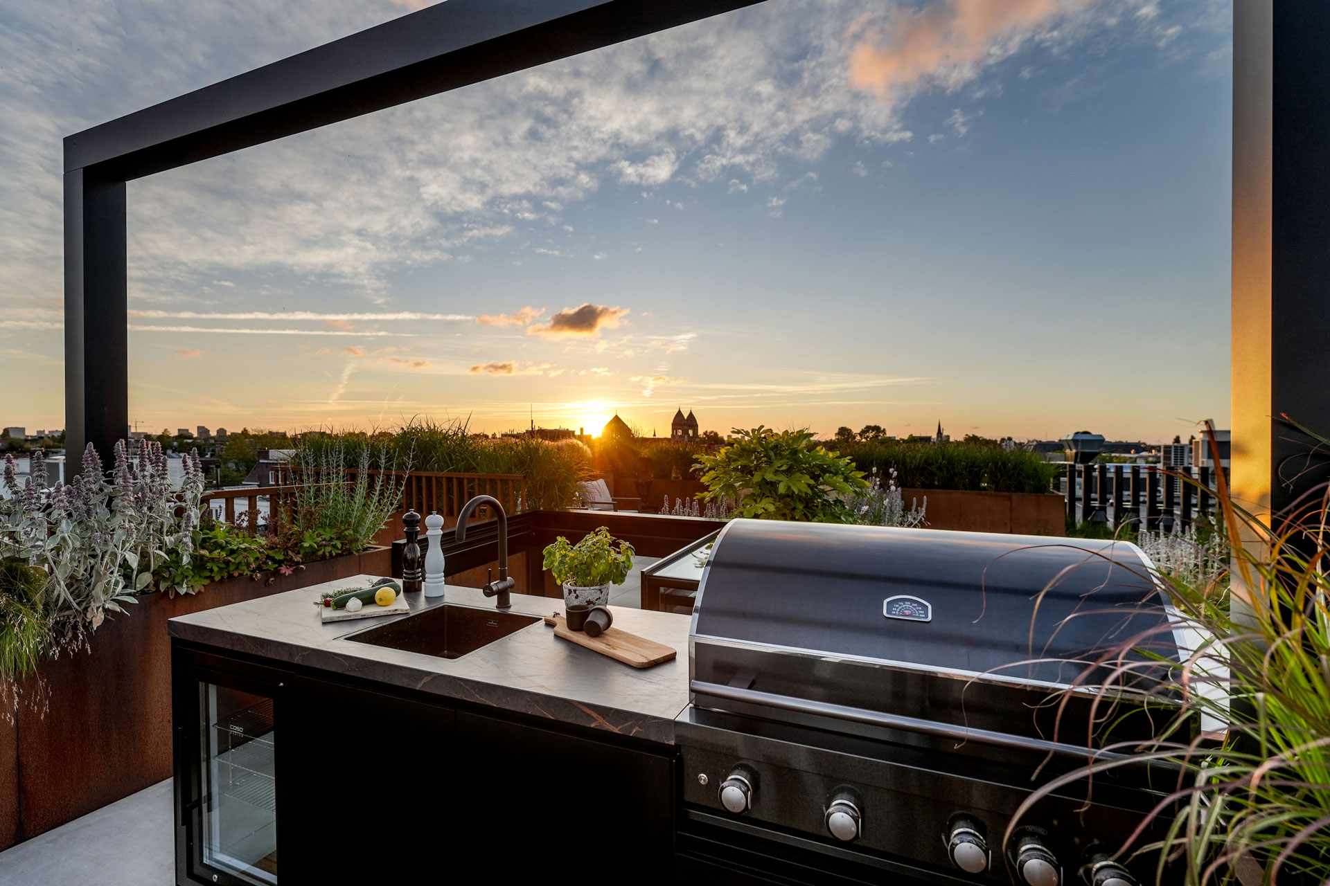 Buitenkeuken onder de pergola met bbq en minibar.