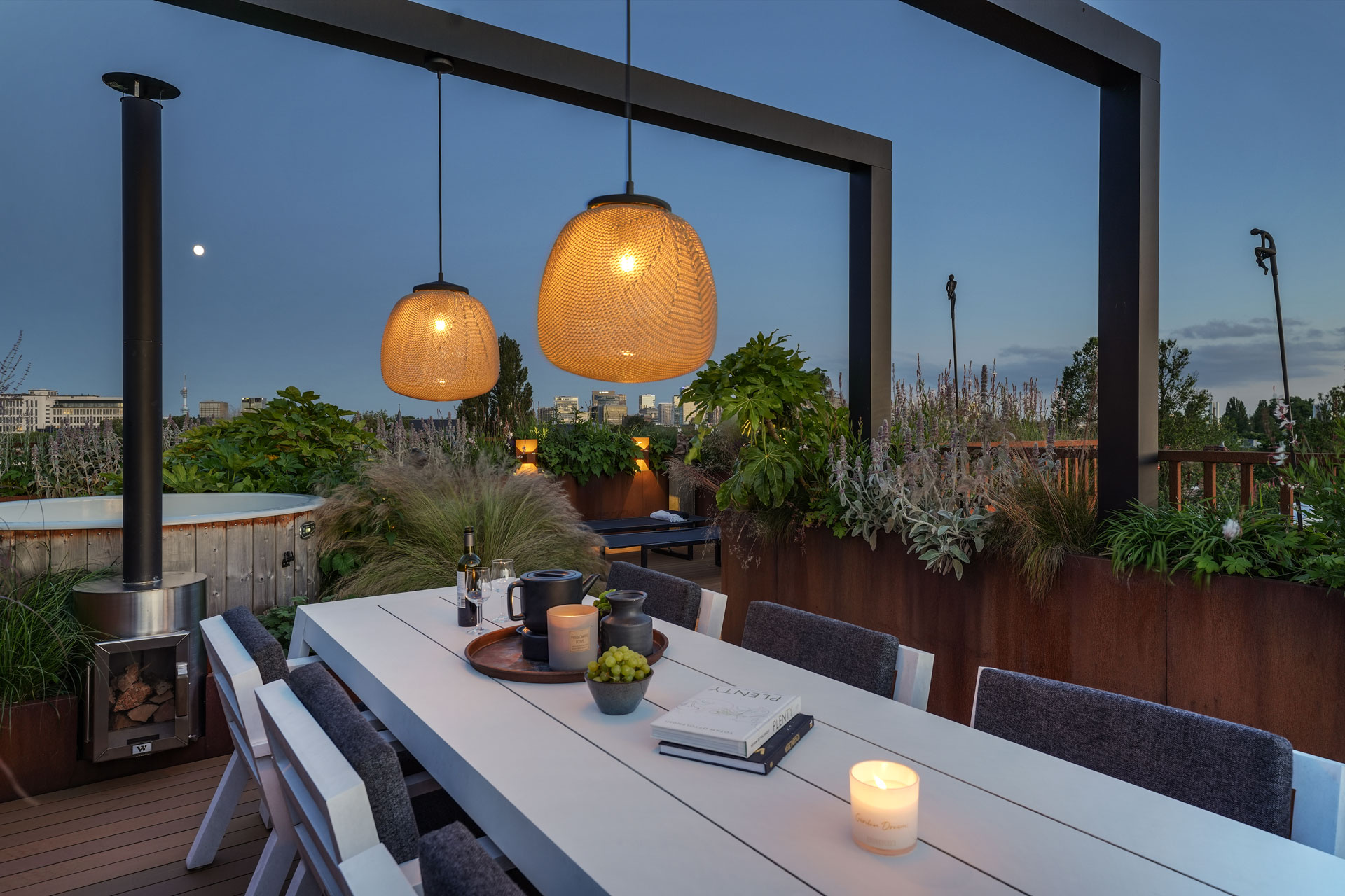 Eettafel onder de pergola met sfeerlampen.