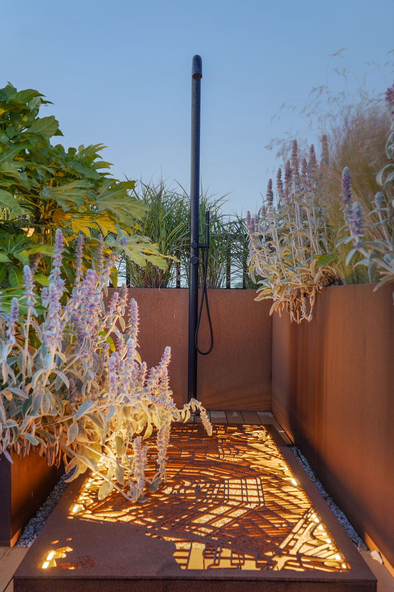 Buitendouche tussen de hoge cortenstale borders.