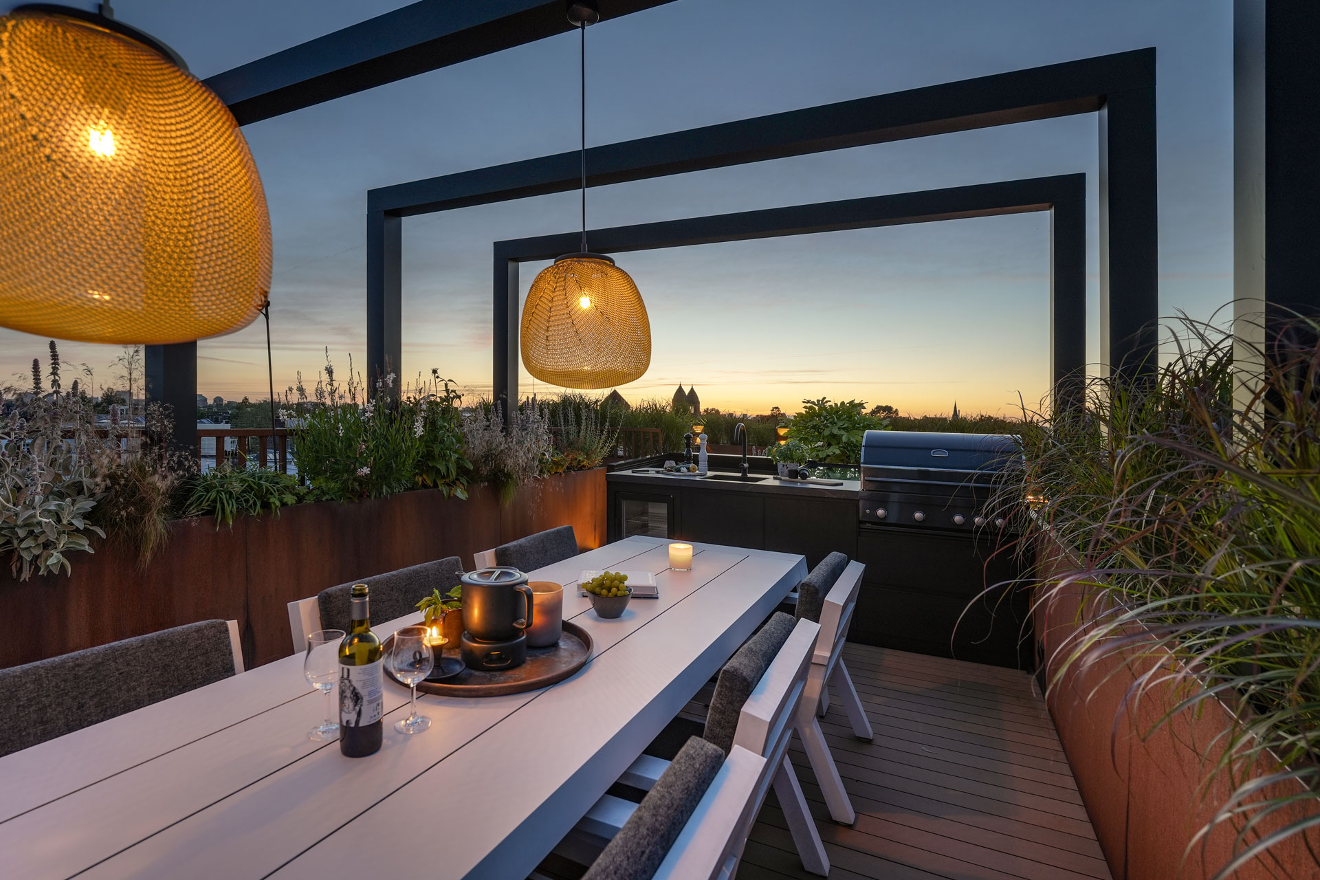 Eettafel met luxe buitenkeuken onder de pergola.