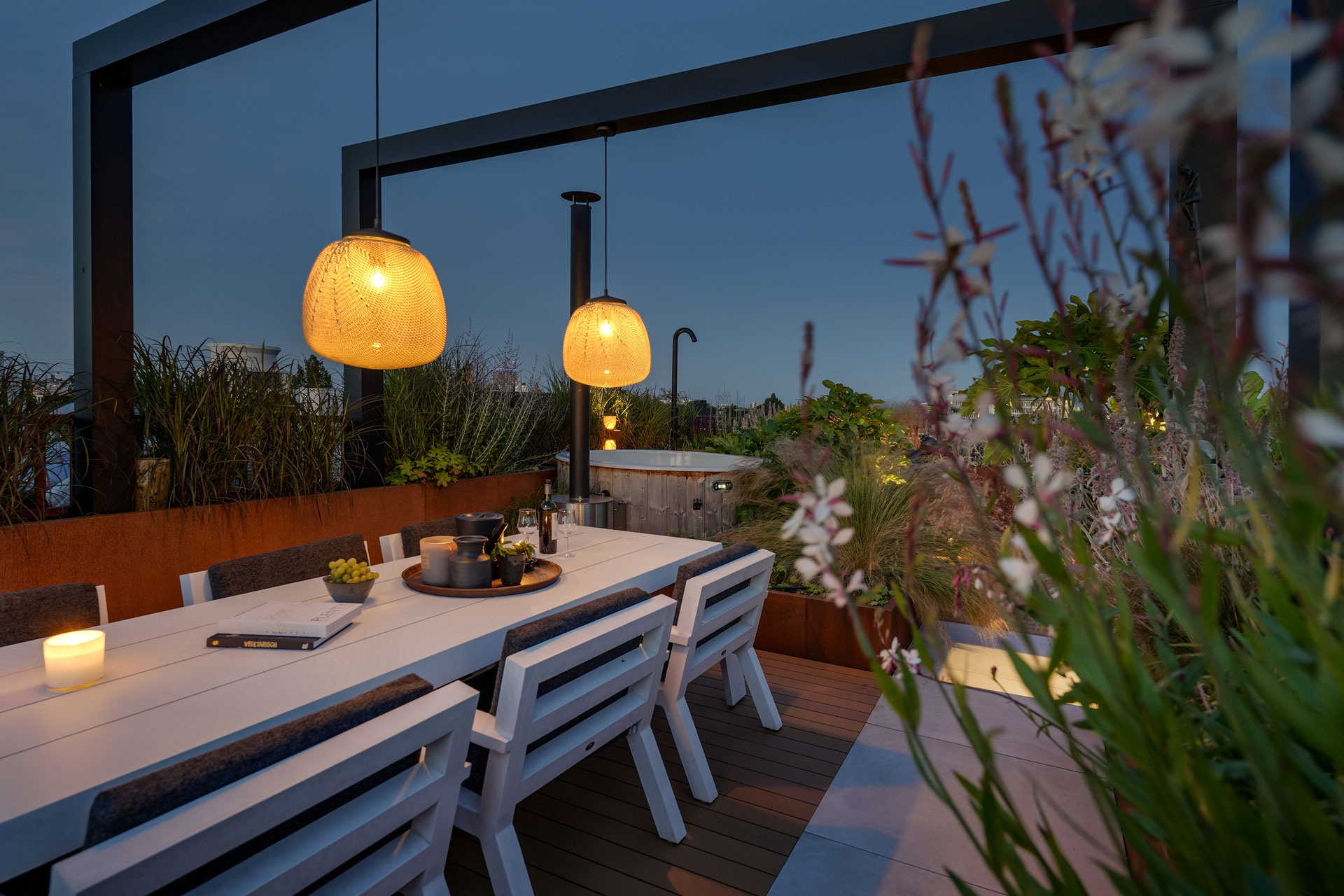 Sfeervol dakterras met pergola en hanglampen.