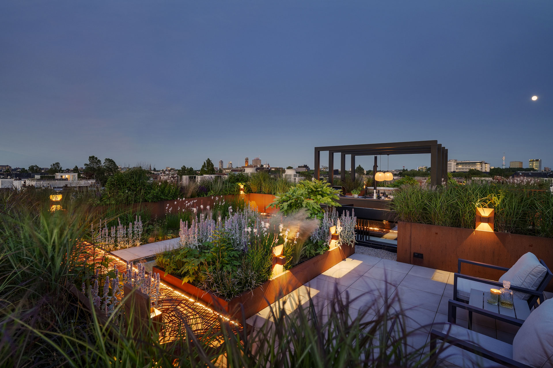 Keramisch terras met zithoek en cortenstaal borders.