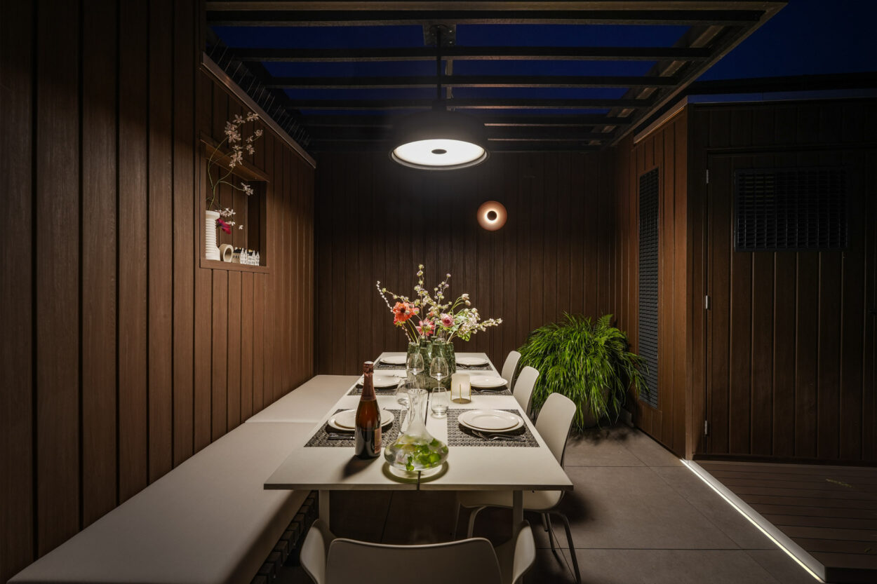 Eettafel met sfeervolle lamp er boven op het dakterras.