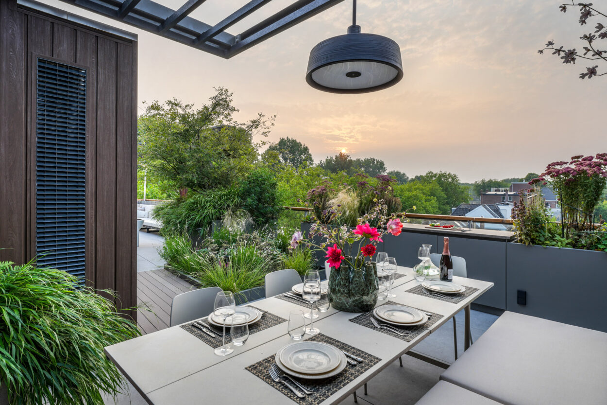 Eettafel op het Esthec terras met een lamp er boven.