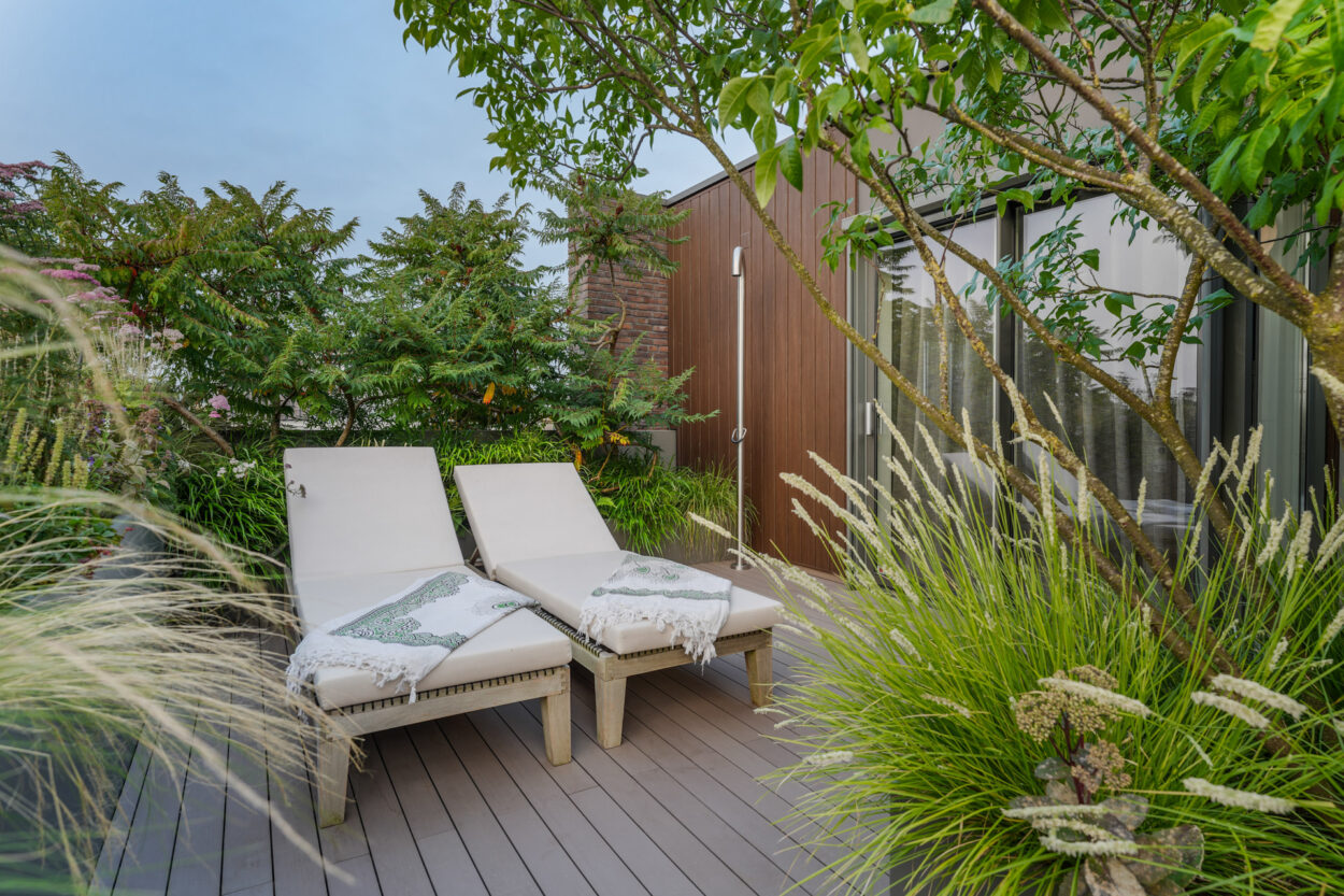 Buitendouche en ligbedden tussen het groene van de daktuin.