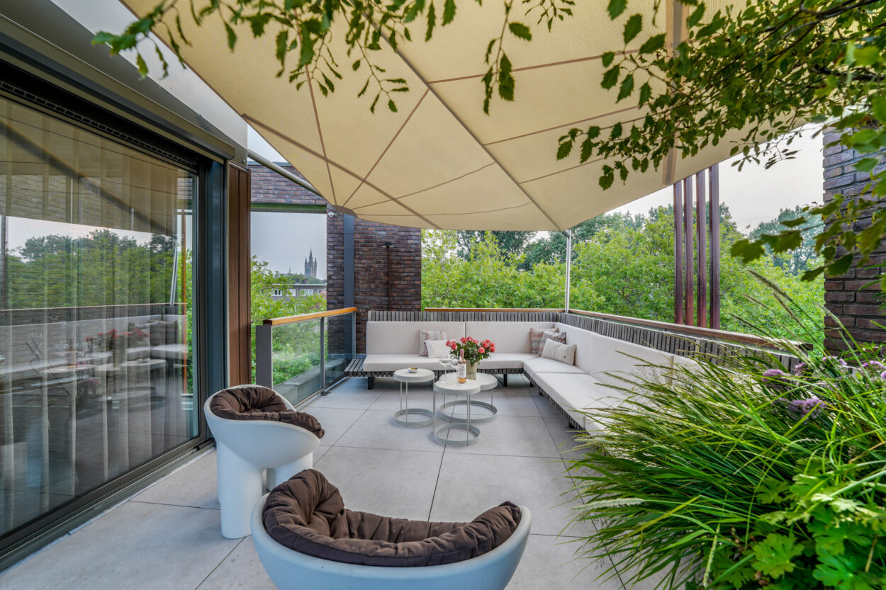 Schaduwdoek boven het terras met loungebank.